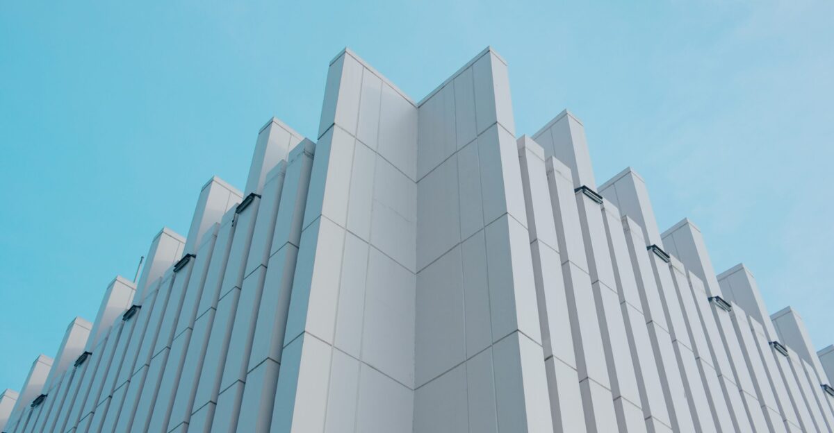 a tall white building with a blue sky in the background