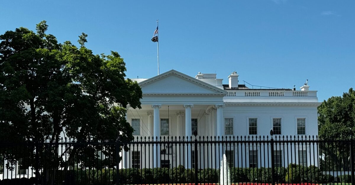 A white house with a black fence in front of it