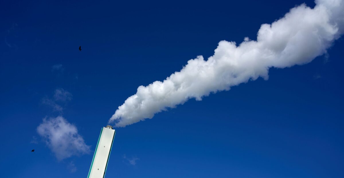 A smokestack emits from the top of a tall building