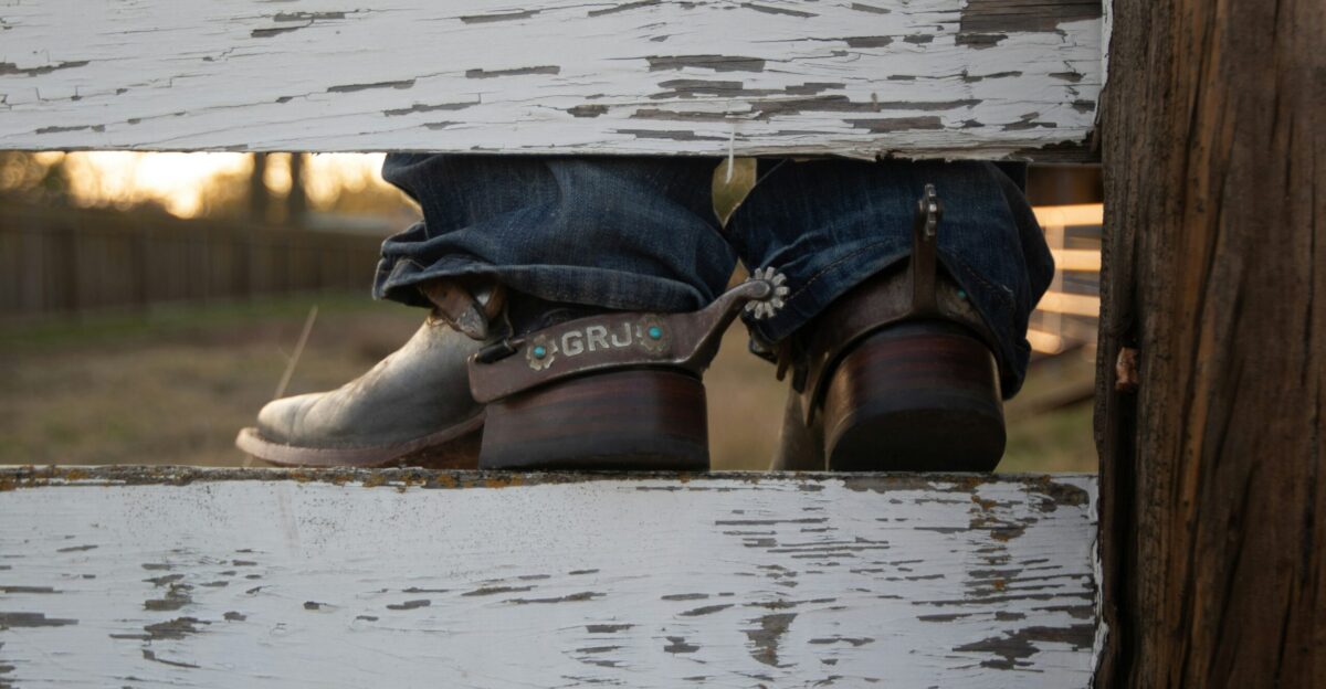 A pair of shoes sitting on top of a wooden fence