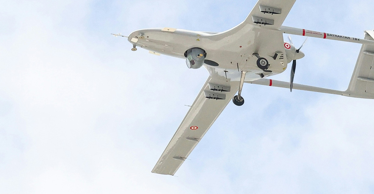 A small airplane flying through a blue sky