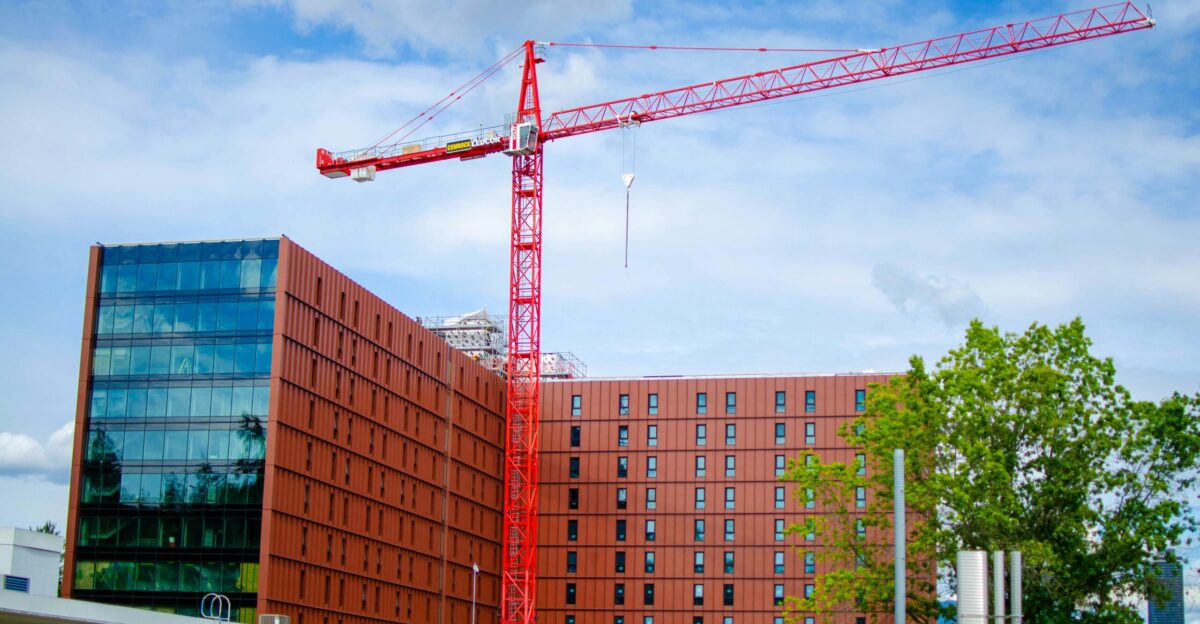 A crane is standing in front of a building under construction
