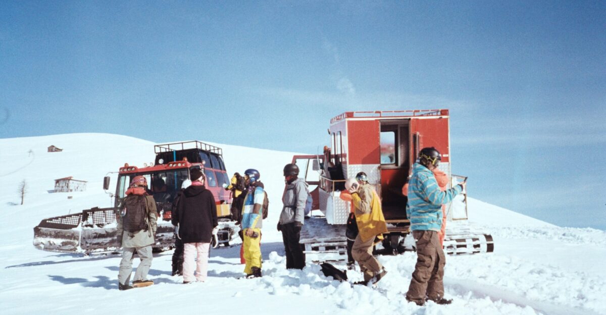 A group of people standing around a truck in the snow