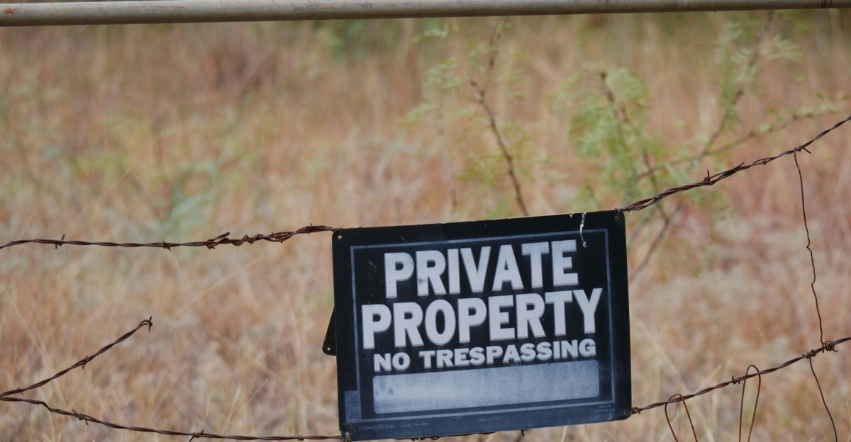 A private property sign is posted on a fence