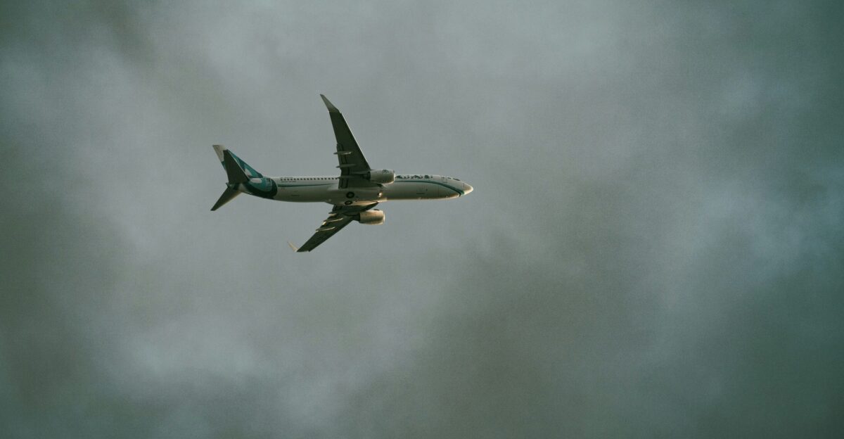 Airplane soaring through a cloudy overcast sky