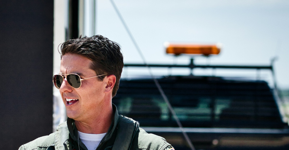 A smiling pilot puts on his flight gear