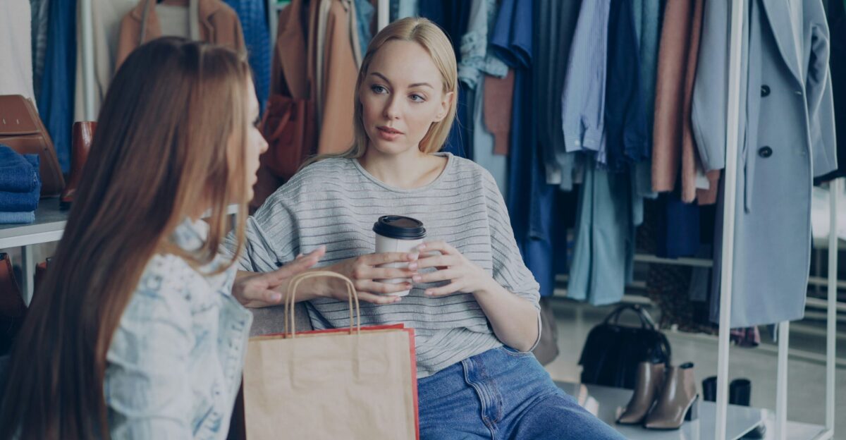 Two women chat in a clothing store