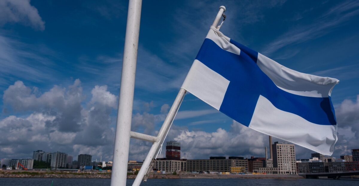 The finnish flag waves against the blue sky