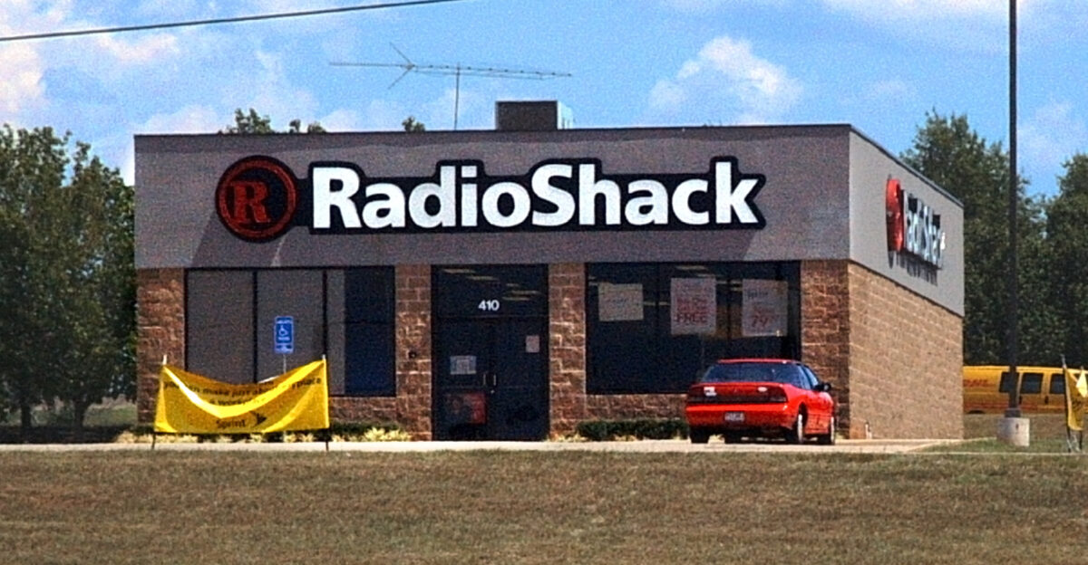 A free-standing RadioShack electronics store in Texarkana Incidentally a DHL delivery van is visible on the road behind the store