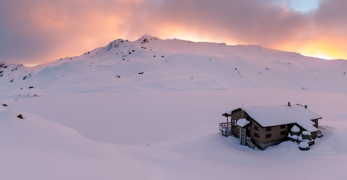 Winter Angelus Hut with Angelus Lake behind it In the clouds no name peak 1860m can be seen Picture taken during the sunset Nelson Lakes National Park New Zealand