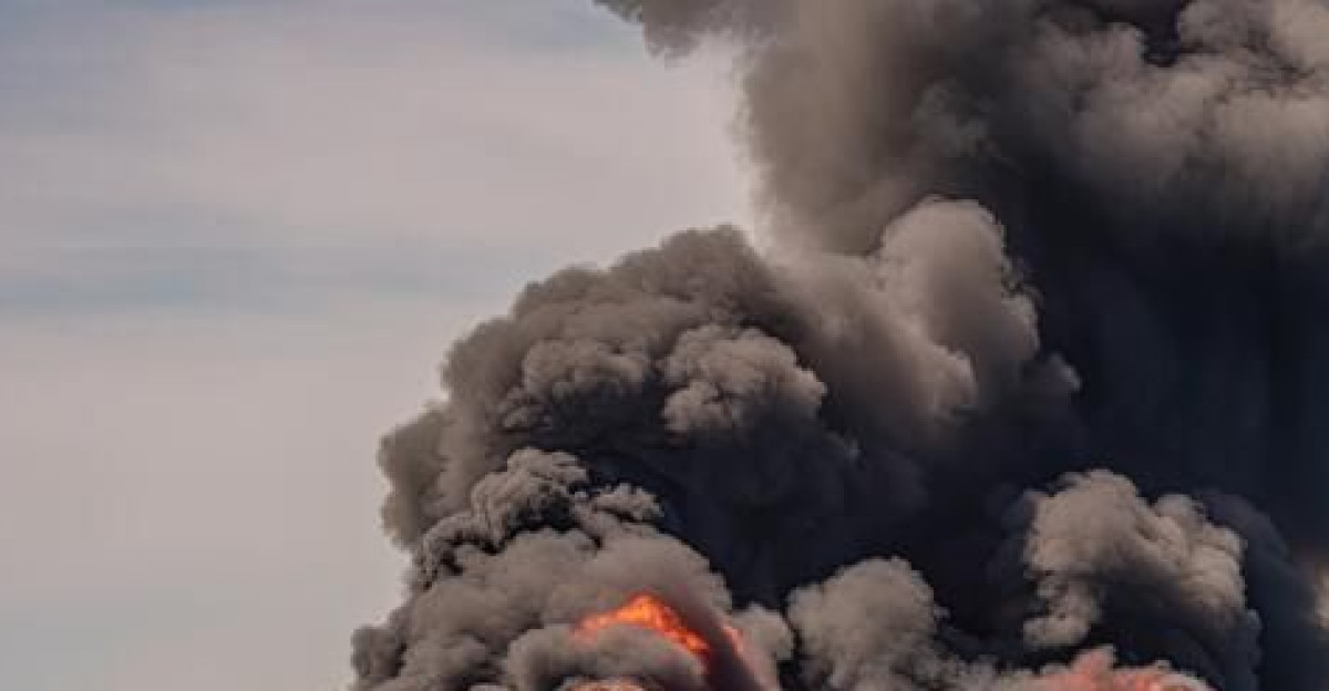 A cargo ship in the middle of the sea is engulfed in flames Thick black smoke billows f by Jabba Jaws