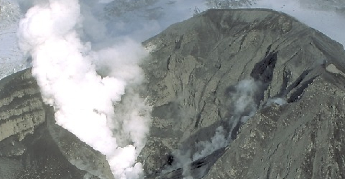 <p>Aerial view of ash-covered Crater Peak after an explosive eruption on September 16-17. Before the 1991-1992 activity, a small pond covered Crater Peak's crater floor; it disappeared shortly before the first eruption on June 27. After the September episode, scientists estimated that the crater was filled with explosive debris to a thickness of more than 20 m.
</p><p>Crater Peak vent is the youngest volcanic feature at Mount Spurr. It's a flank vent that occupies the breach of a large caldera formed by a large landslide and explosive eruption of Spurr. Crater Peak began erupting at least 6,000 years ago; an earlier cone built in the same location as Crater Peak has ben mostly destroyed, presumably by glaciation.
</p>
Crater Peak has been the source of all eruptive activity at Mount Spurr in the past several thousand years.