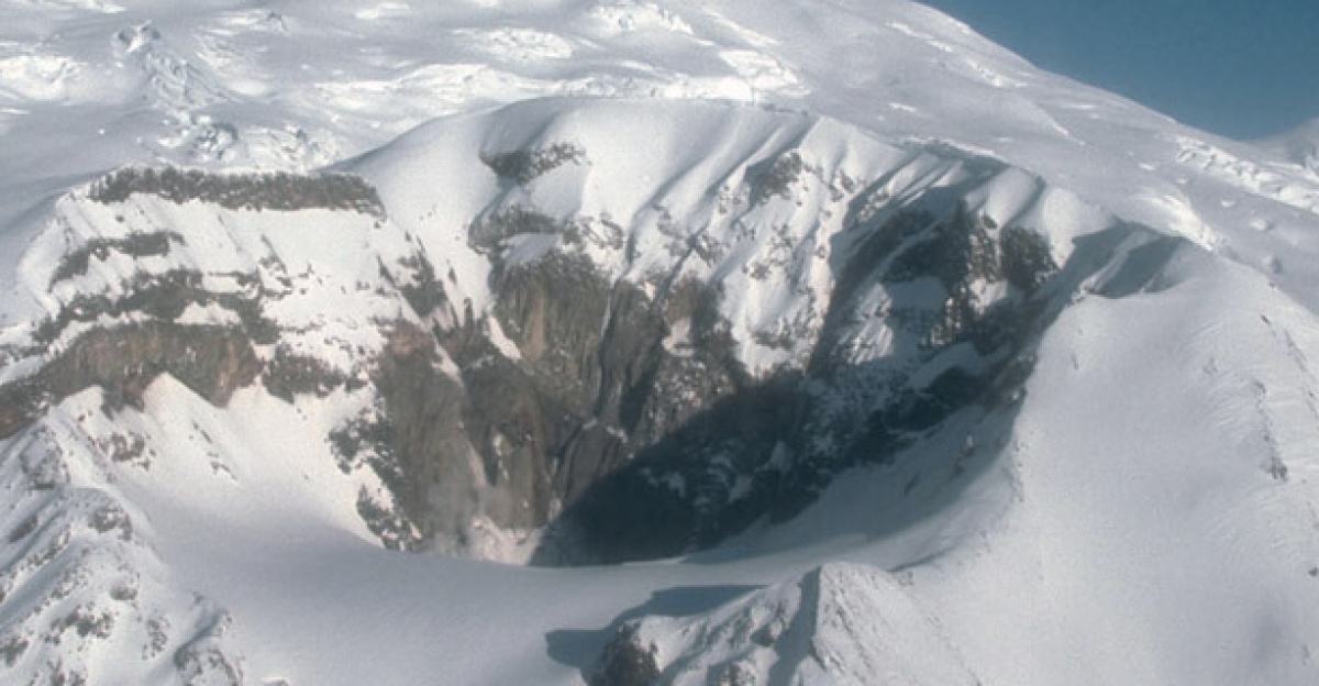 Crater Peak, a satellite vent of Mount Spurr volcano, and the snow- and ice-covered summit lava dome complex of Mount Spurr beyond. View is to the north.