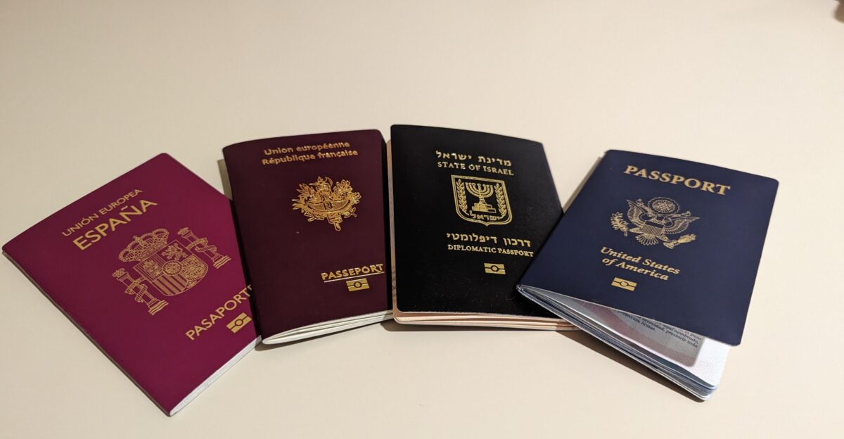 A picture of four different passports next to each other a Spanish passport a French passport an Israeli diplomatic passport and an American passport