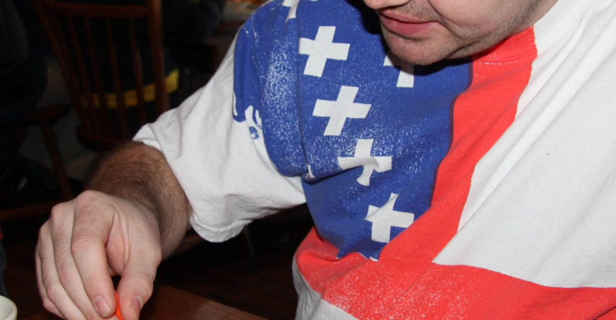 A guest who has given permission for his photo to be used playing triangular peg solitaire while waiting for a meal at the Cracker Barrel restaurant in Wisconsin Dells Wisconsin United States