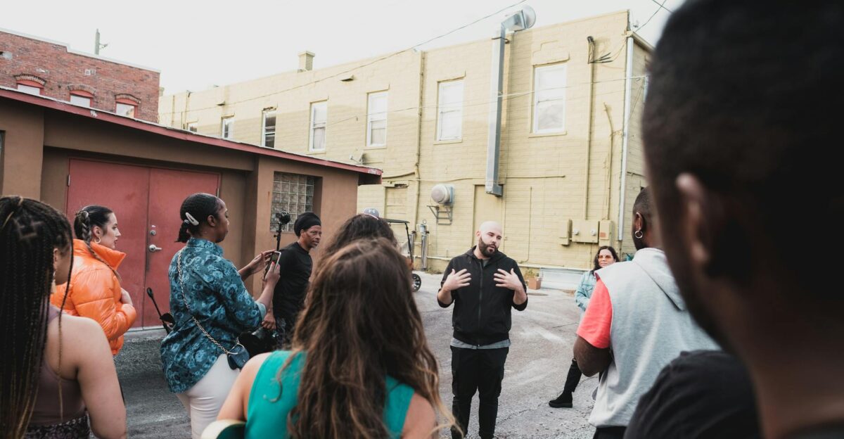A diverse group of adults engaging in a community meeting on an urban Sanford street