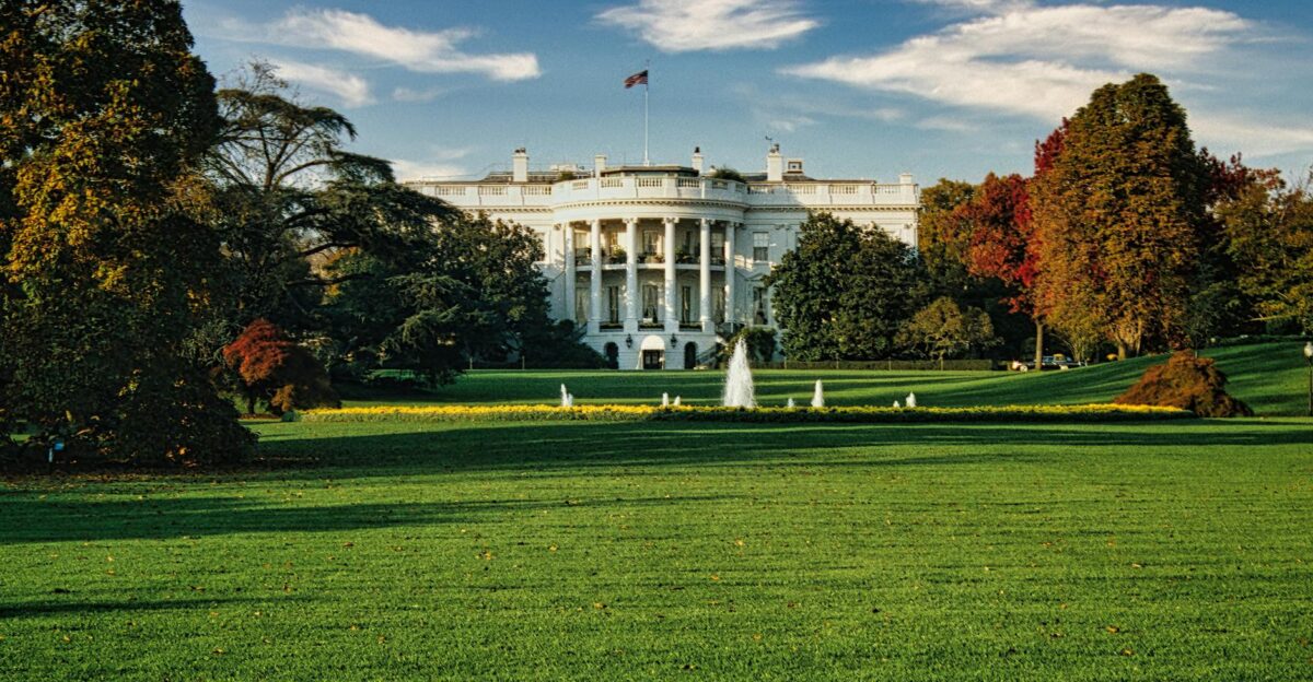 A view of the White House surrounded by autumn foliage and a central fountain in Washington DC