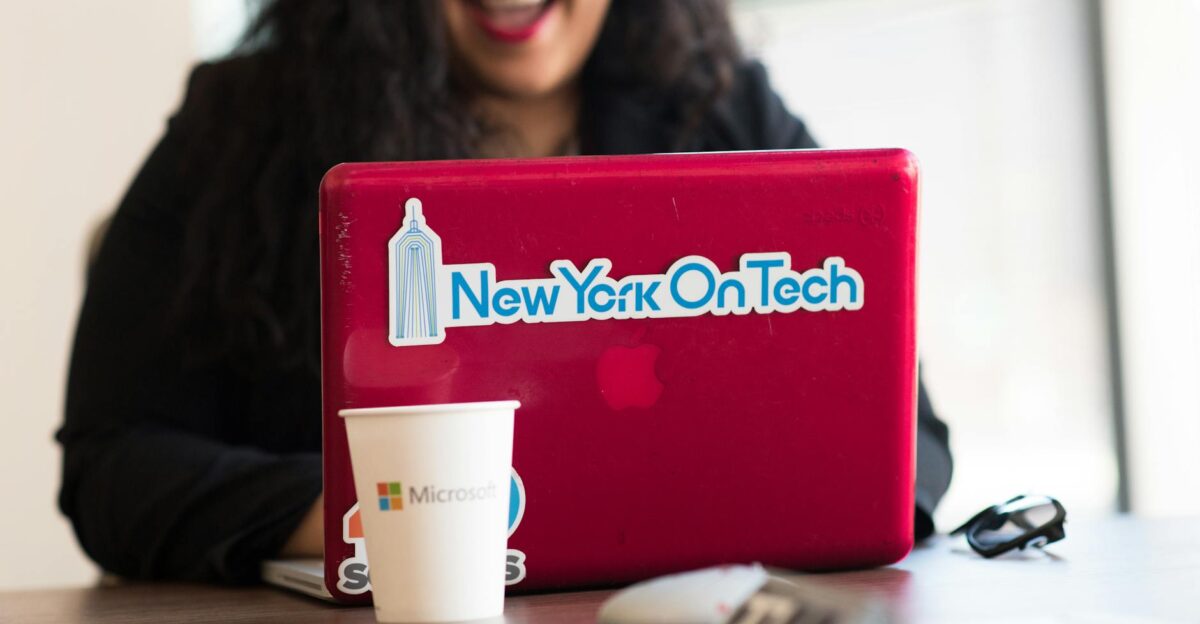Young woman working remotely with a laptop in a modern indoor office setting showcasing tech culture