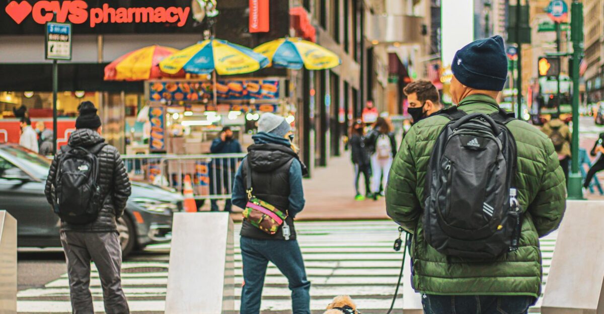A vibrant street scene in New York City showing pedestrians crossing and a dog on a leash