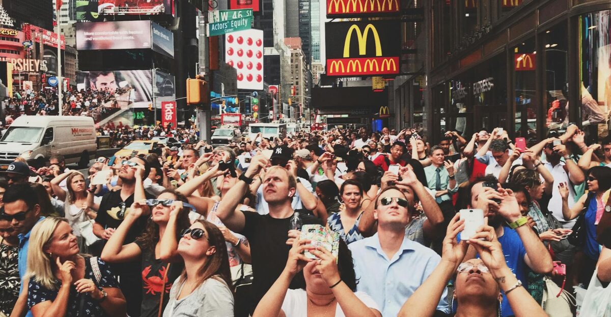 Diverse crowd in Times Square New York City capturing moments with smartphones