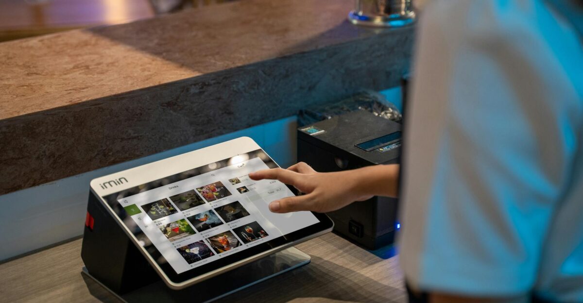 A close-up of a person interacting with a touchscreen in a restaurant setting showcasing modern technology