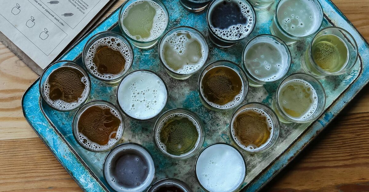 Aerial view of assorted beer glasses on a rustic tray perfect for brewery tasting sessions