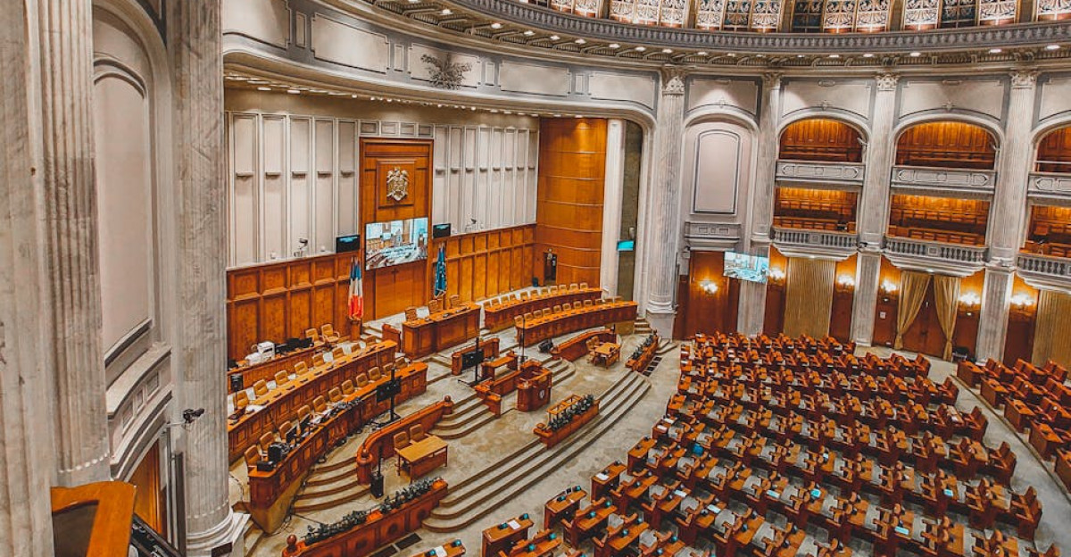 Stunning view of a grand neoclassical parliament chamber with intricate dome ceiling and seating arrangement