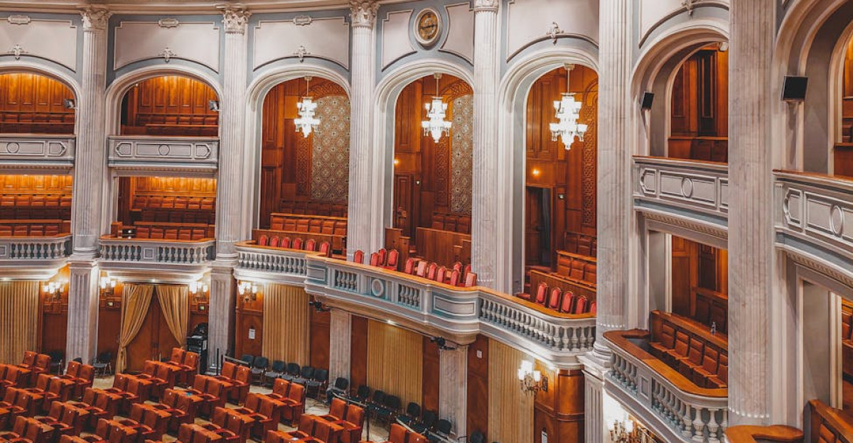 Stunning interior of a grand parliamentary chamber with a decorative dome and seating