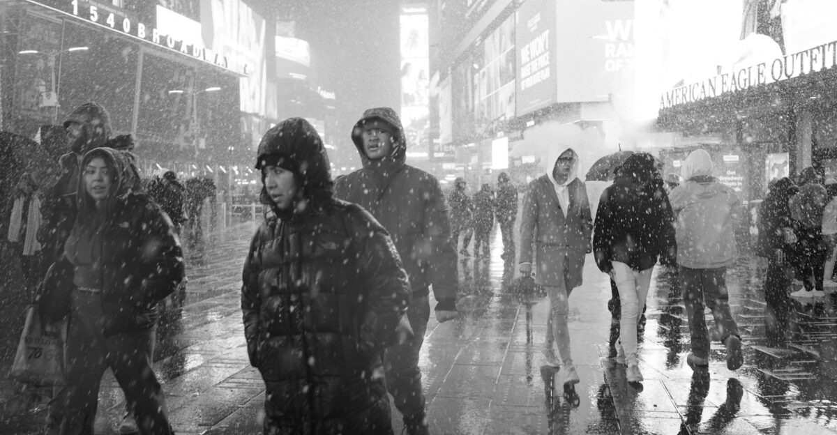 People walking in the snowy streets of Times Square New York City during winter
