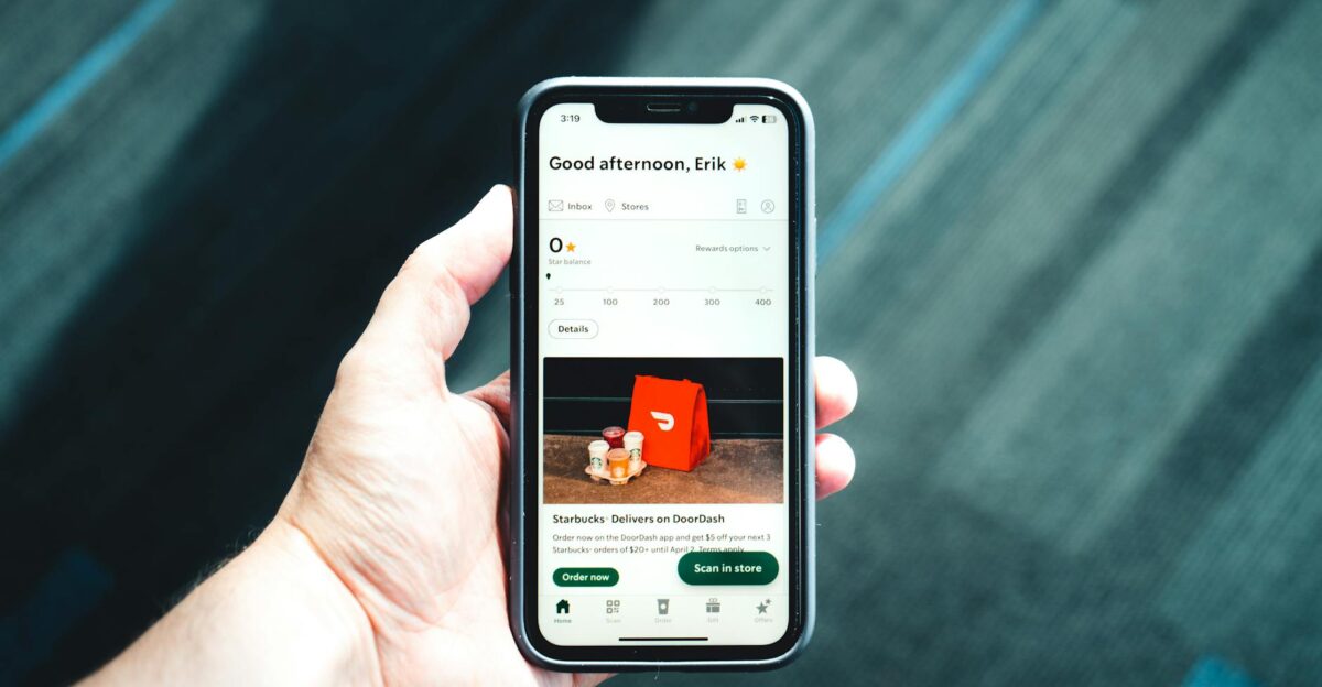 Close-up of a smartphone with a delivery app interface in a person s hand emphasizing modern e-commerce