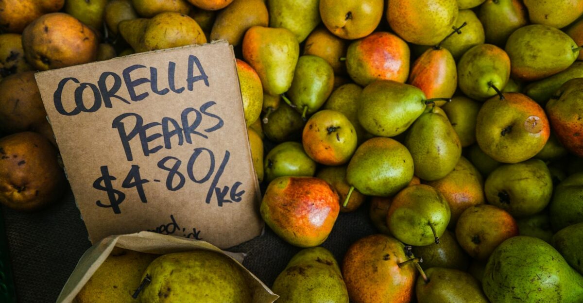 Close-up of Corella pears with price tag at a market showcasing their fresh and juicy appeal