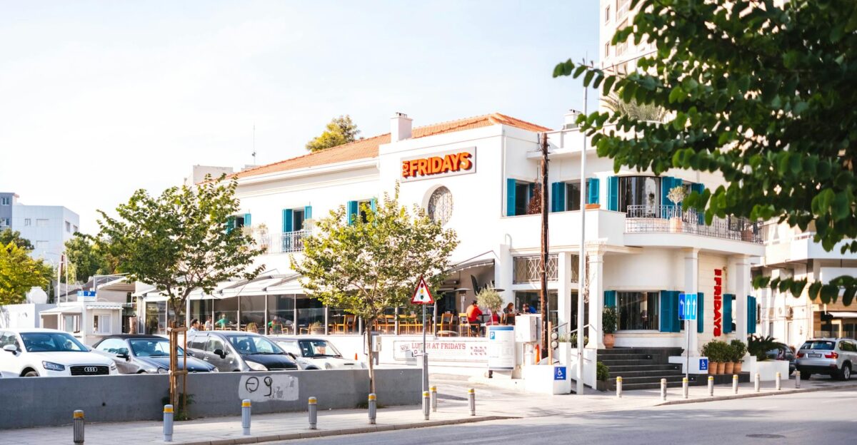 Charming urban scene featuring a restaurant cars and pedestrians on a sunlit street