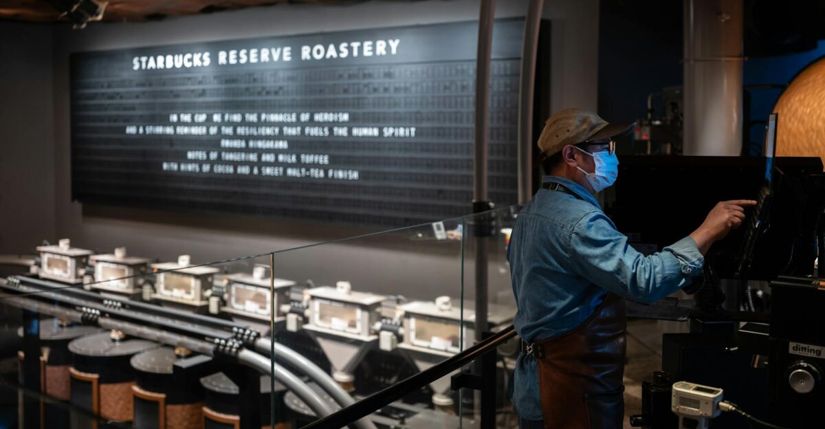 A barista operates machinery at Starbucks Reserve Roastery showcasing the coffee production process