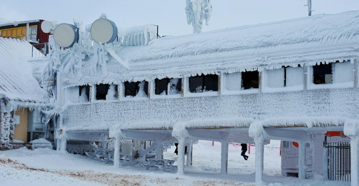 A frozen building covered in thick ice and snow showcasing extreme winter conditions