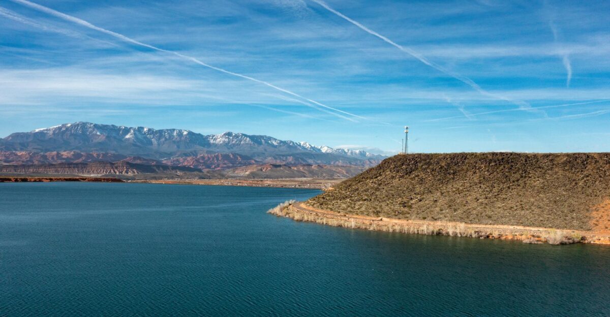 Peaceful lake scene with snowcapped mountains and clear blue sky in Hurricane Utah