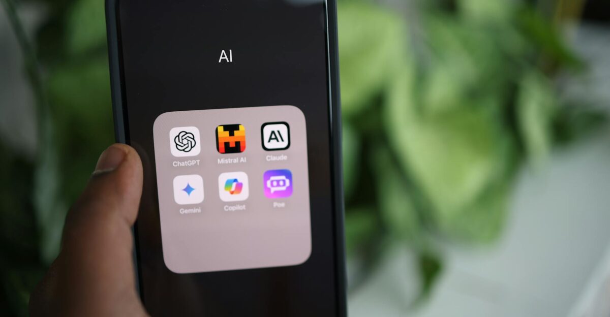 Close-up of a hand holding a smartphone with AI applications on screen