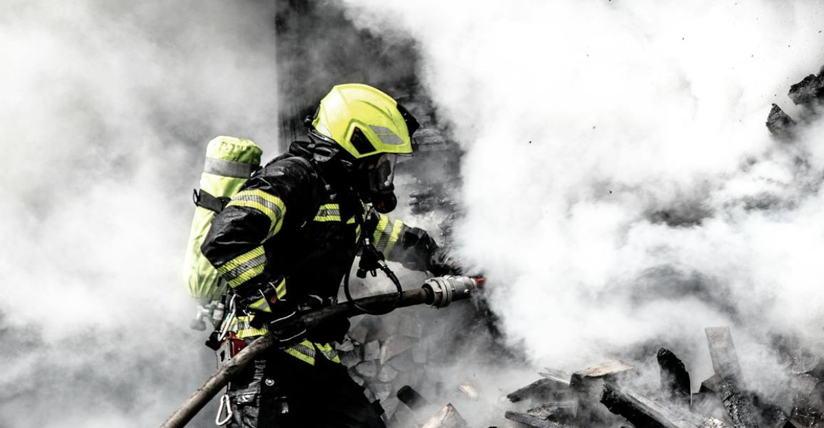 A determined firefighter fights a raging fire amidst thick smoke highlighting bravery and courage