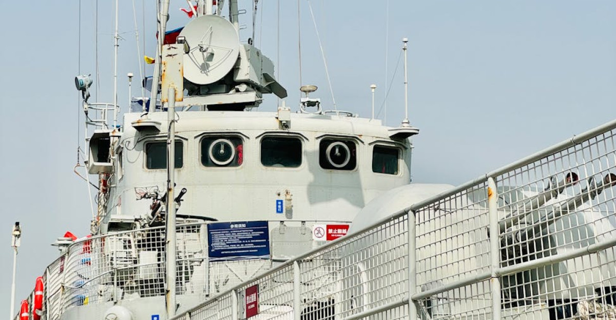 Close-up of a military warship adorned with colorful signal flags under a clear sky in Tianjin China