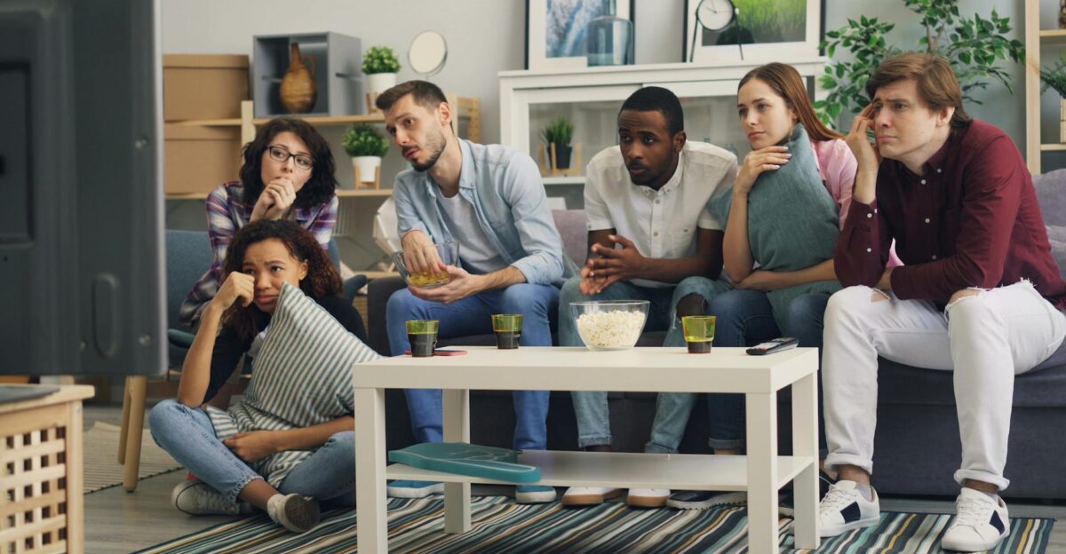 A group of friends enjoying a movie night together indoors with snacks and drinks