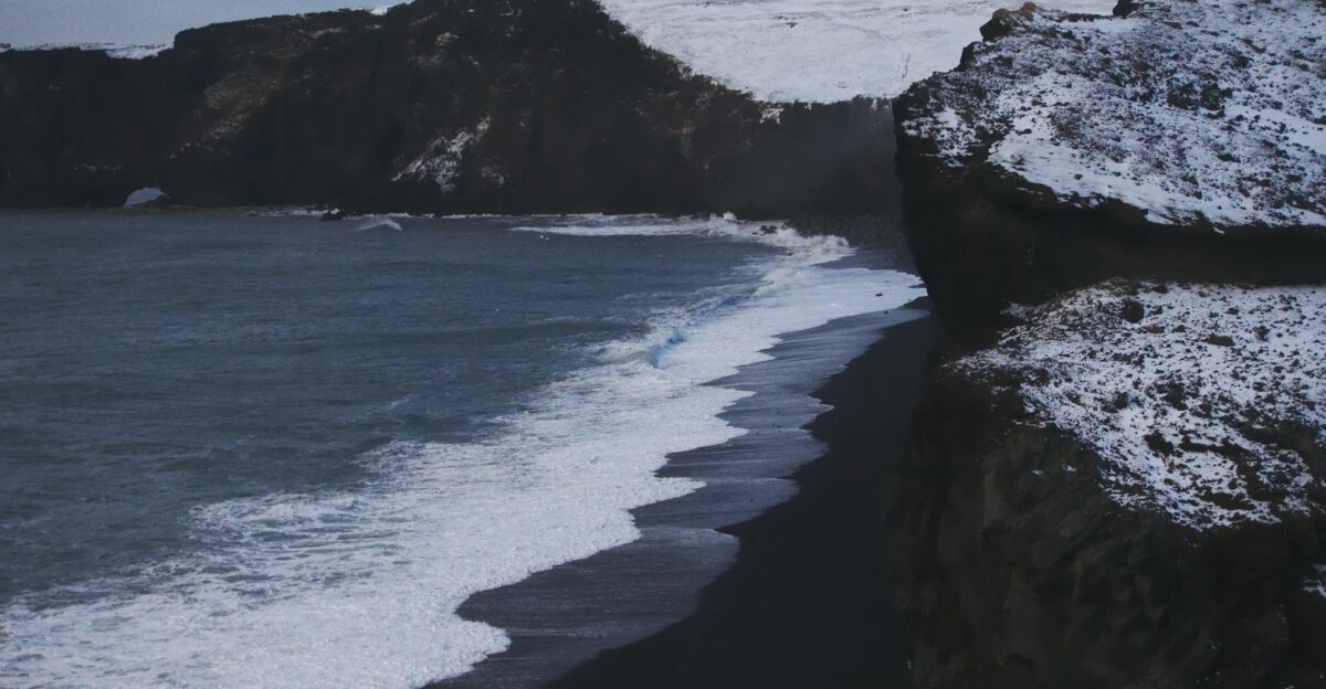 Capture the icy beauty of Vik s iconic black sand beach during winter with dramatic cliffs and waves