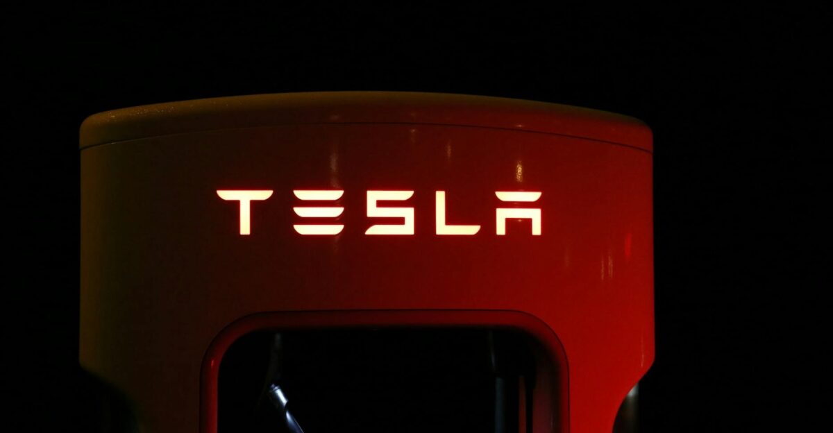 Close-up of a Tesla charging station illuminated at night showcasing modern automotive technology