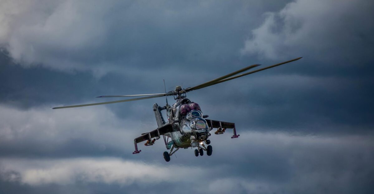 A Mi-24 military helicopter flying through overcast skies in Slovakia