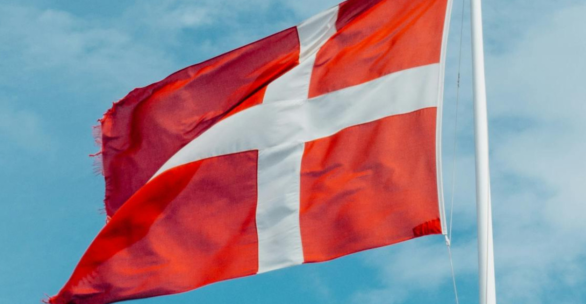 Red and white Danish flag fluttering in the wind symbolizing national pride on a clear day