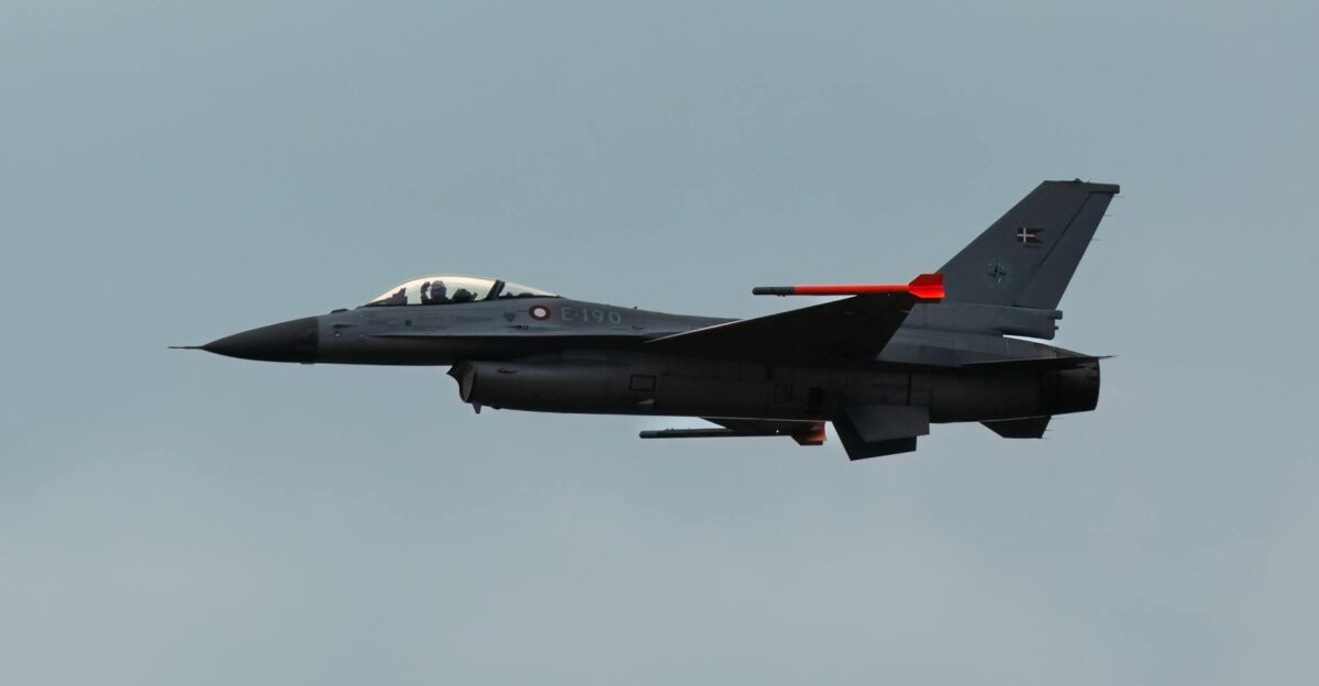 A sleek F-16 fighter jet soaring through a cloudy sky showcasing military aviation