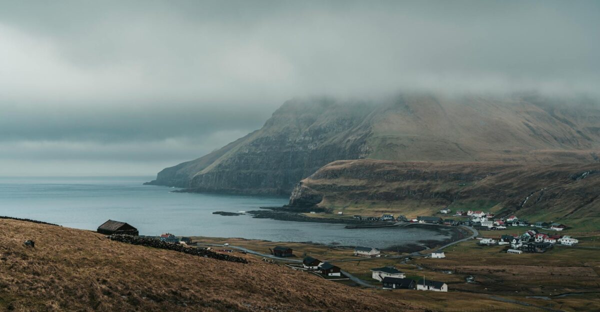 Serene view of a foggy coastline and village in the Faroe Islands