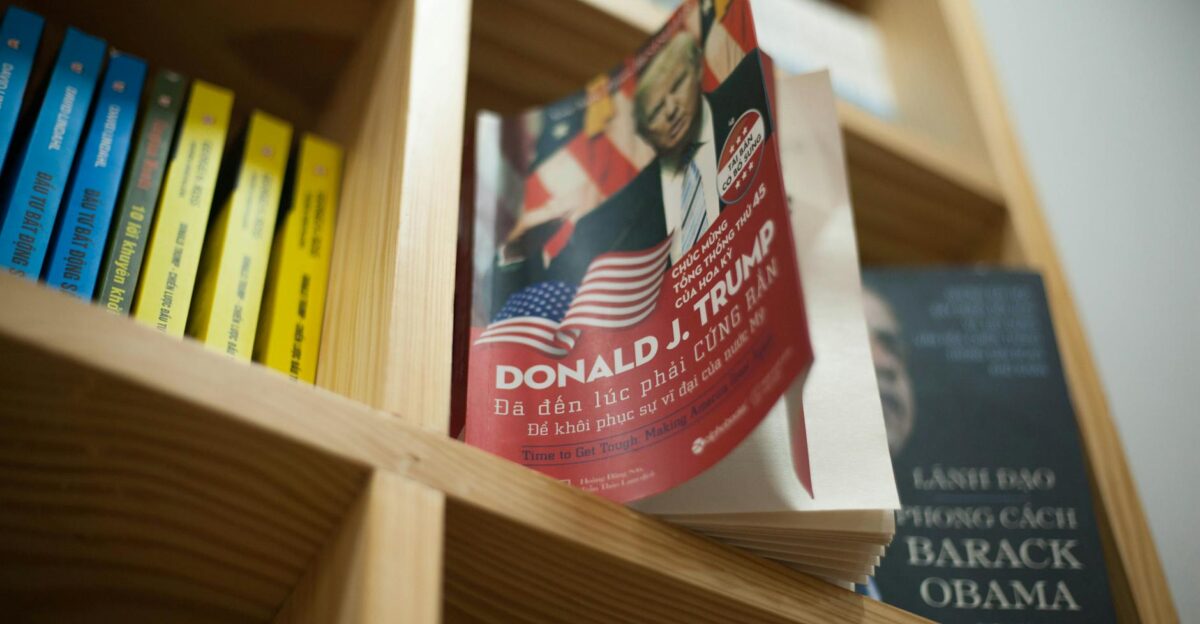 A close-up view of a bookshelf with books featuring political leaders in a bookstore setting