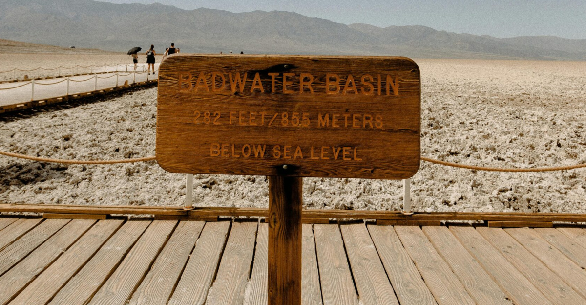 Wooden sign at Badwater Basin, Death Valley, marking elevation below sea level under a clear sky.