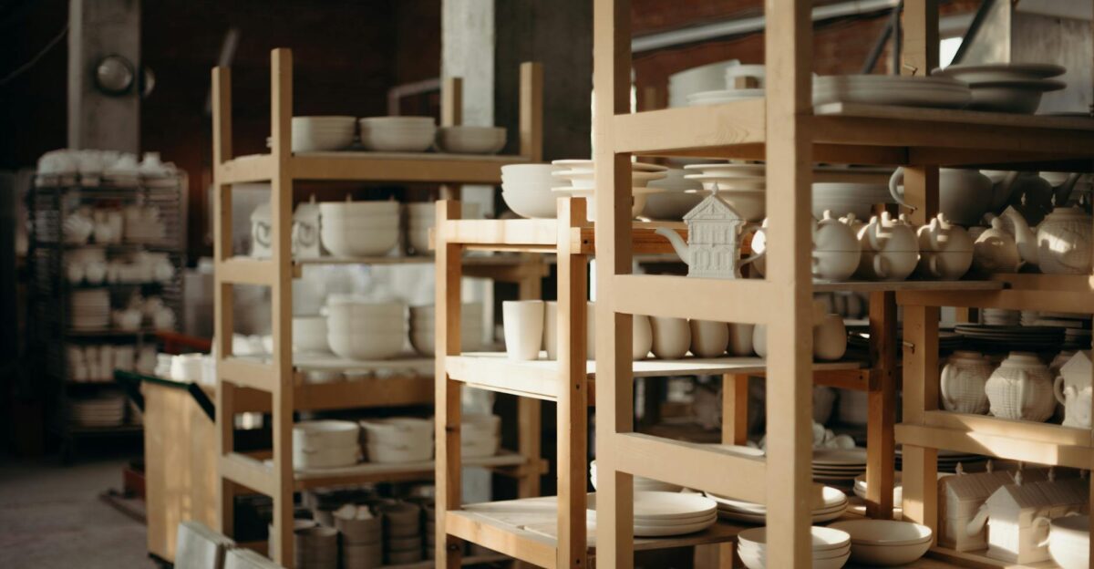 Explore a rustic pottery workshop with handmade ceramics showcasing bowls mugs and teapots on wooden shelves