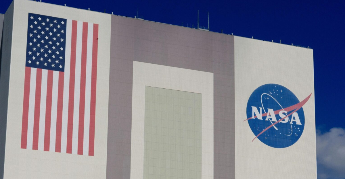 The iconic NASA Vehicle Assembly Building at Kennedy Space Center in bright daylight.