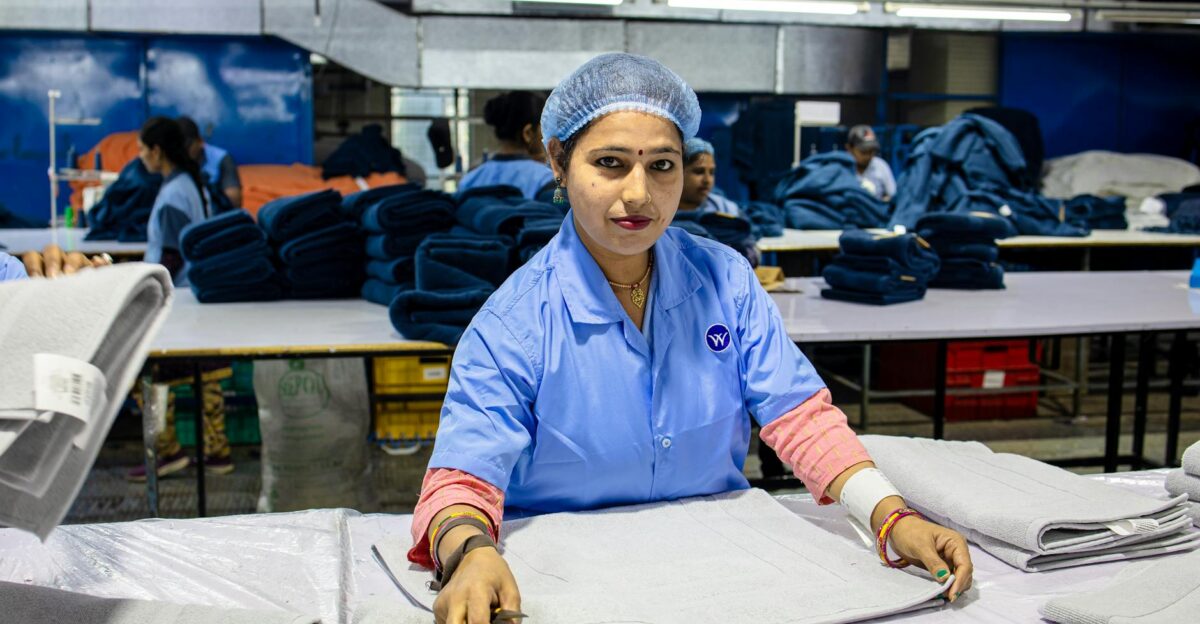 Image of a female textile worker folding fabrics in an industrial setting